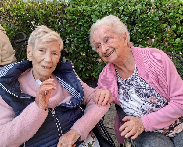 Zwei Seniorinnen lächeln fröhlich.